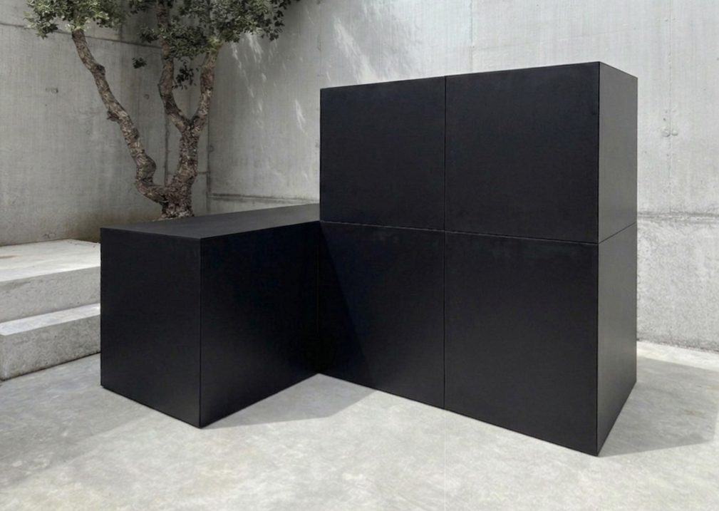 RO. L-step compositie in matzwart aluminium tegen een betonnen wand
