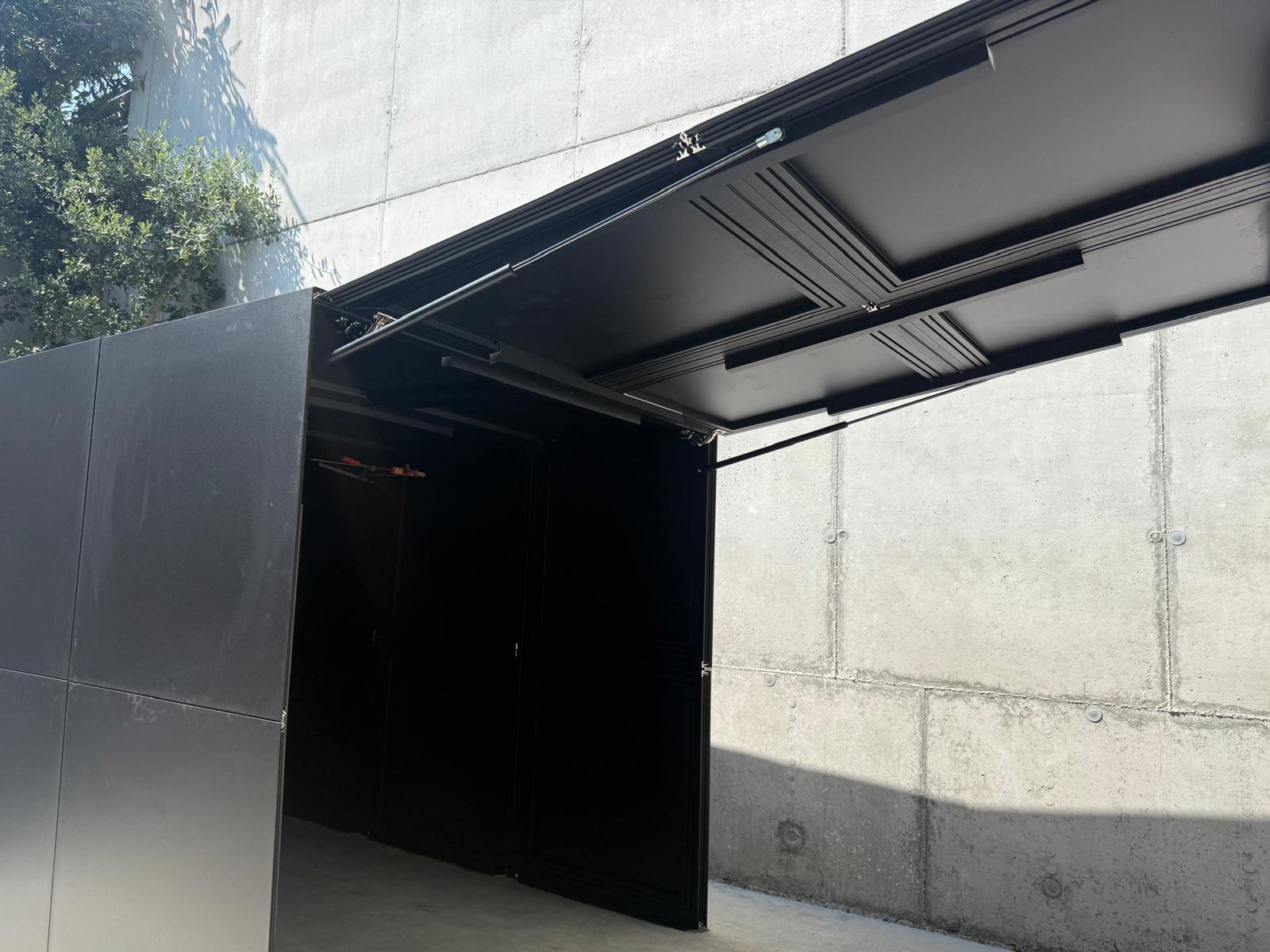 RO. garage module · door tilted open from inside, showing the aluminium ceiling structure